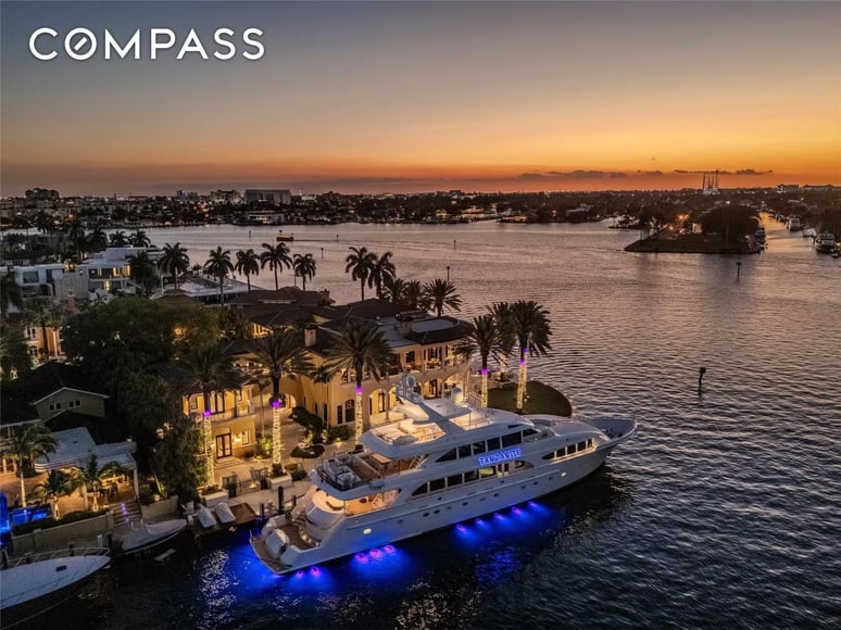 Aerial dusk view of the Fort Lauderdale estate with a superyacht docked at its private waterfront